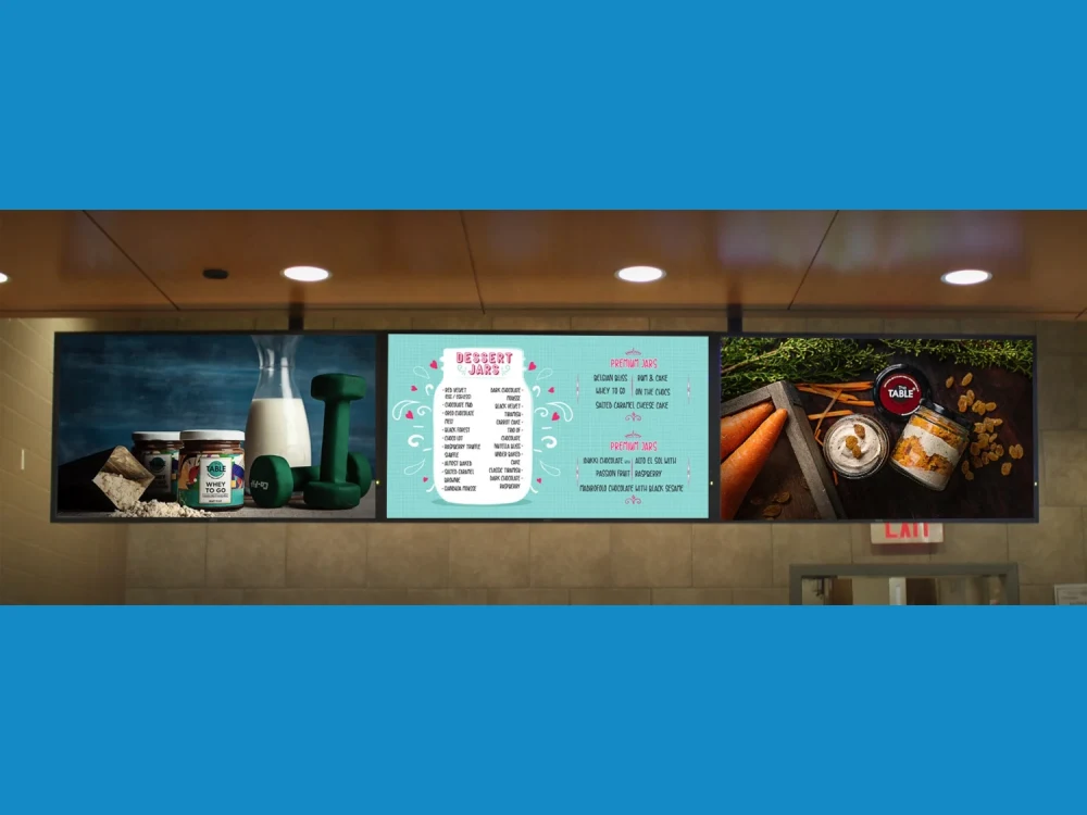 Three ceiling-mounted screens running an image slideshow of products, a dessert menu and branding